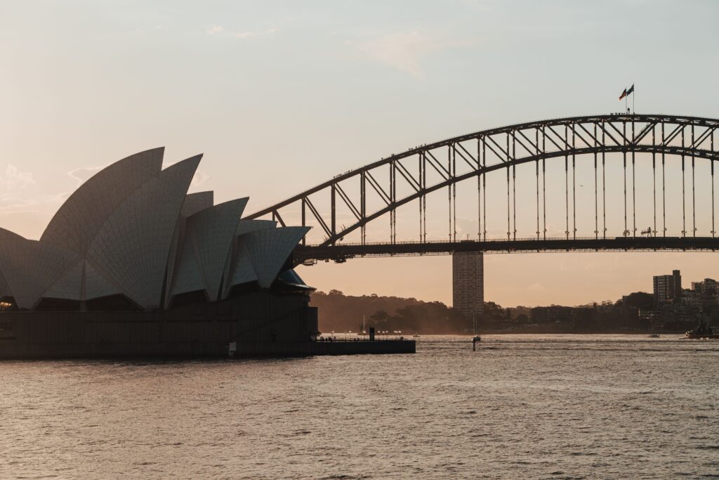 A scenic view of Sydney Opera House and Harbour Bridge at dusk, captured on a tranquil evening.